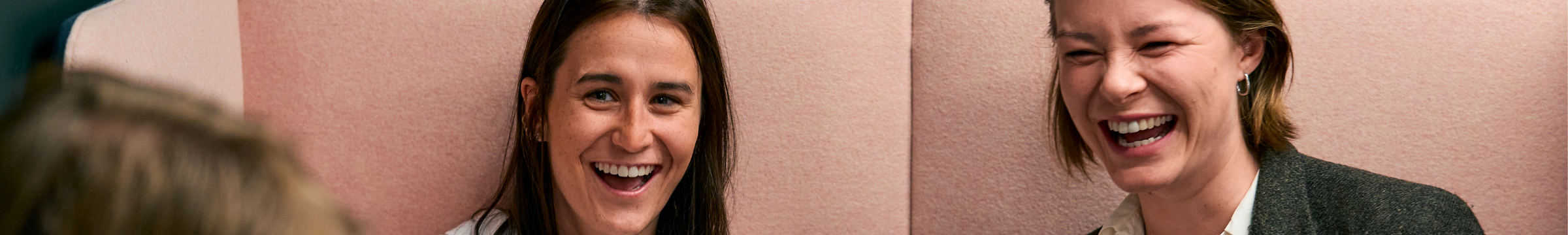 Tre studenter smiler ved bordet