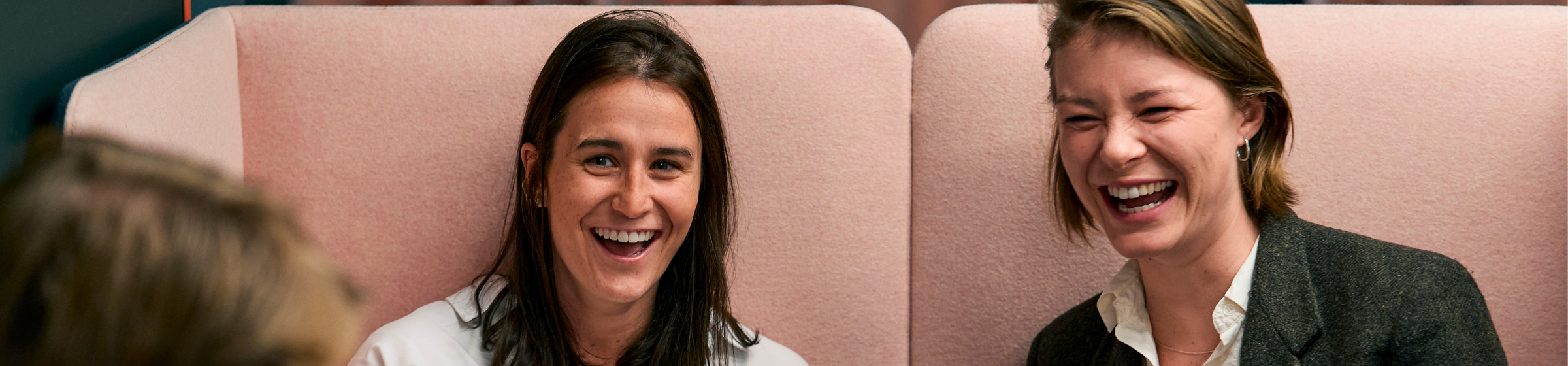 Tre studenter smiler ved bordet