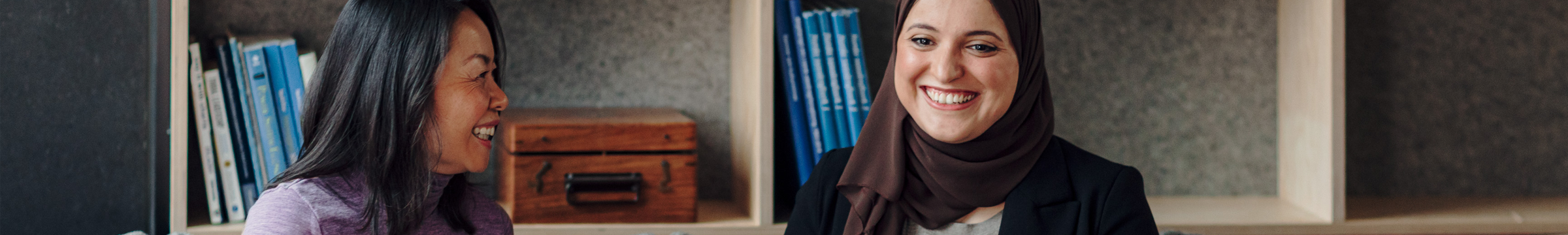 To ansatte snakker sammen og ler