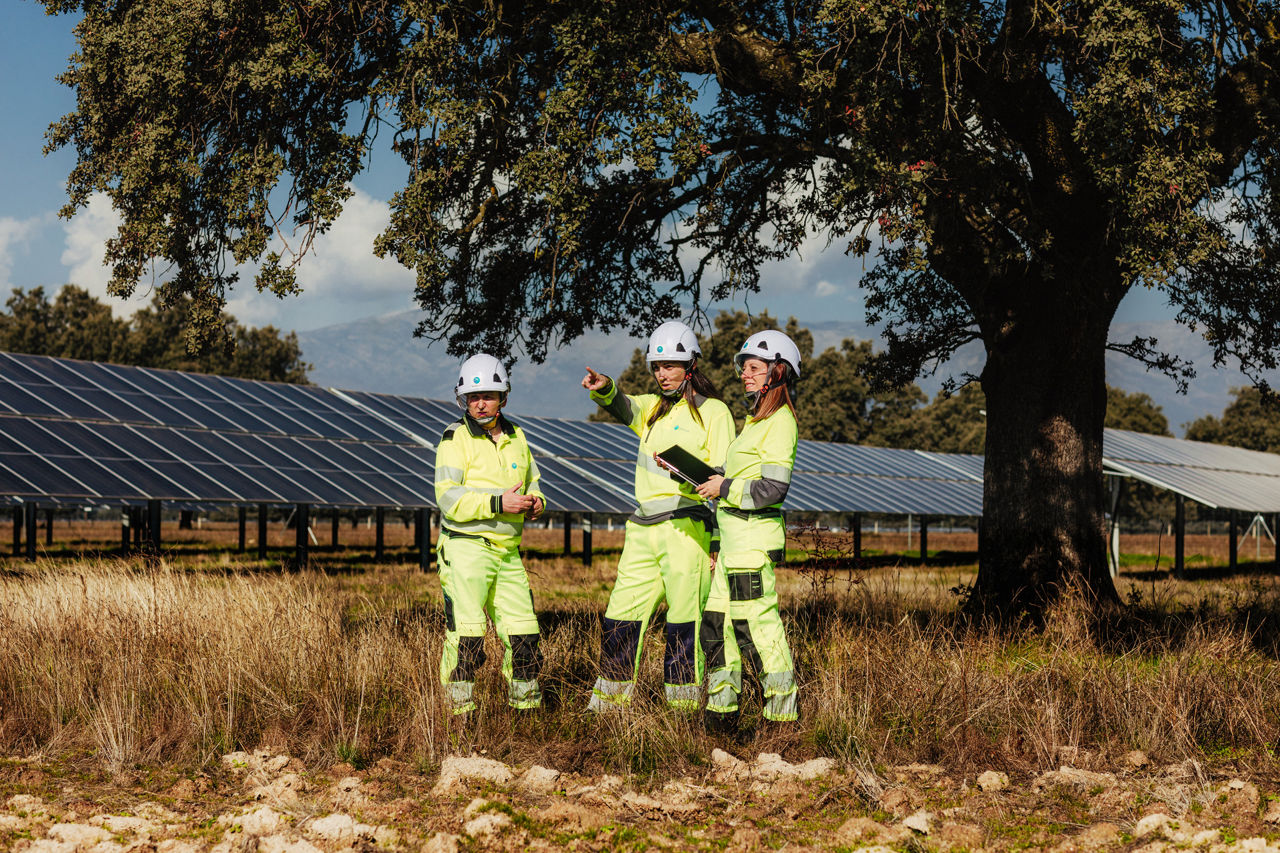 Solcellepaneler og tre ansatte i verneutstyr