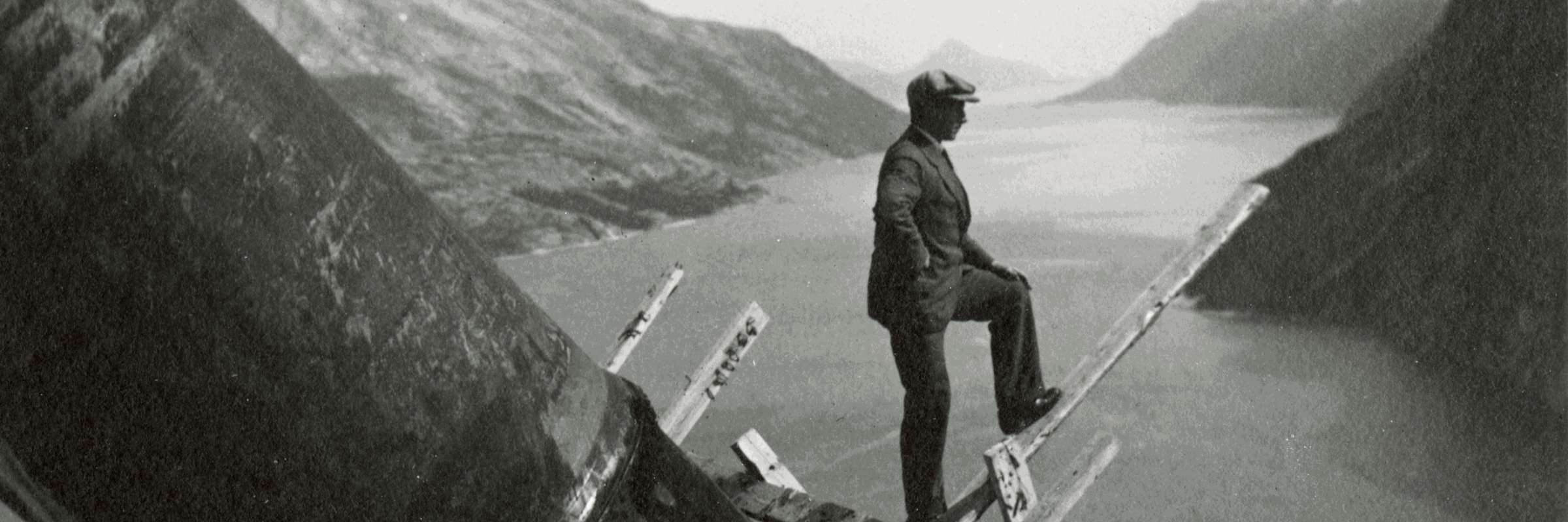 Svarthvitt-bilde av mann som ser utover fjorden