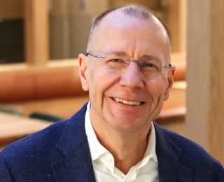 Mann med briller smiler