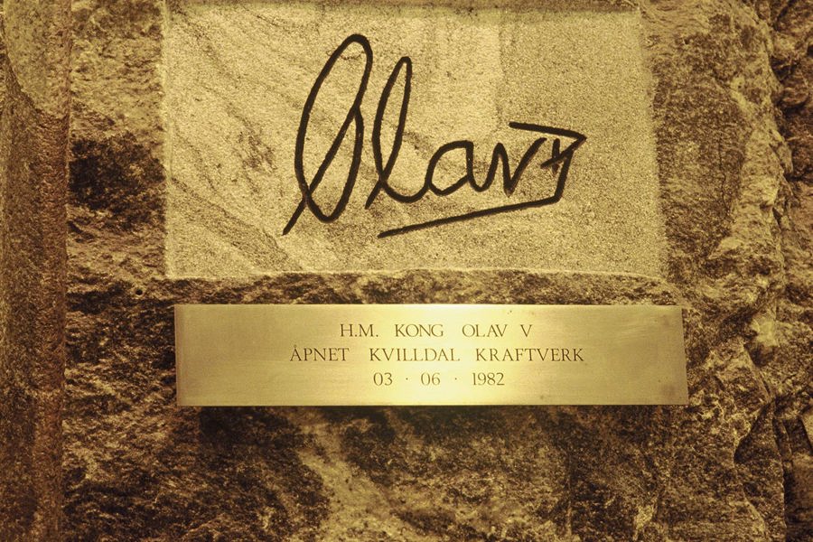 Signatur og skilt der det står «H.M. Kong Olav V åpnet Kvilldal Kraftverk 03-06-1982»