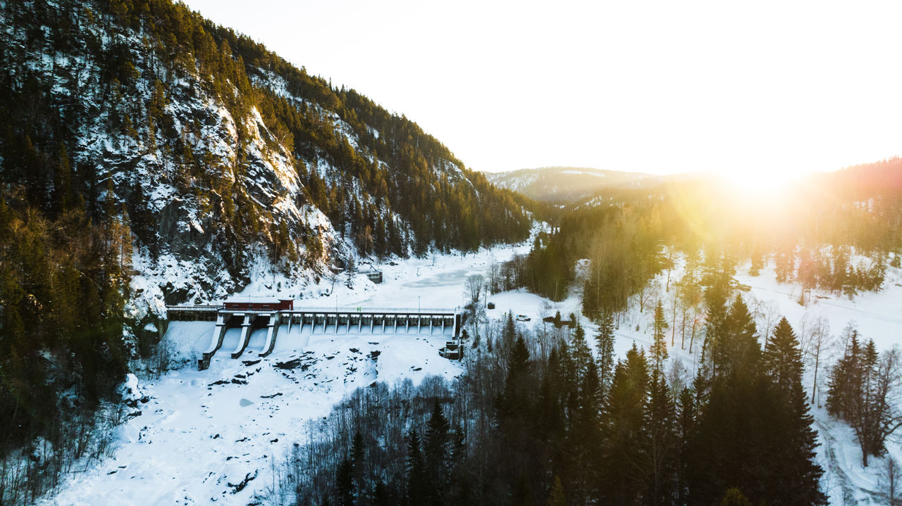 Svean vannkraftverk mellom fjell og i vinterlandskap