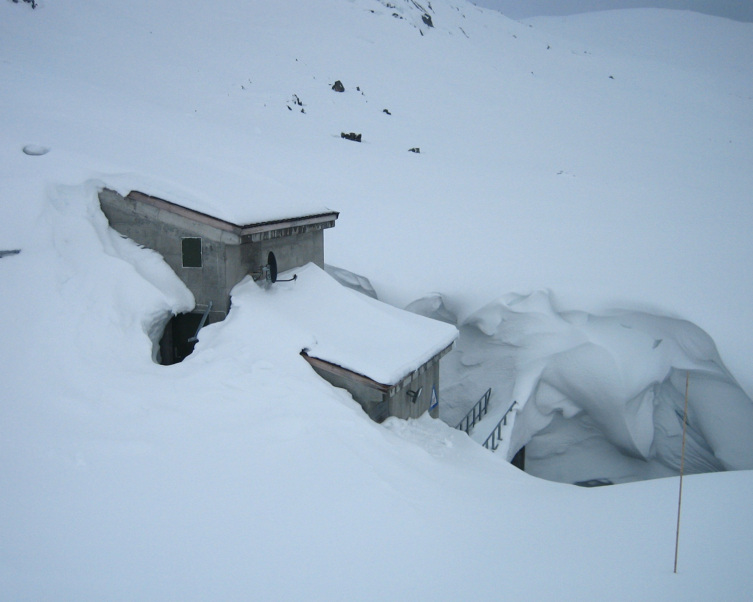 Nedre Bersåvatn kraftstasjon med snø på alle kanter.