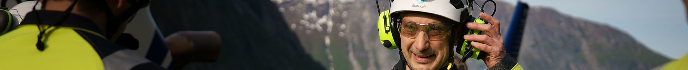 Mann i verneutstyr snakker i en radio