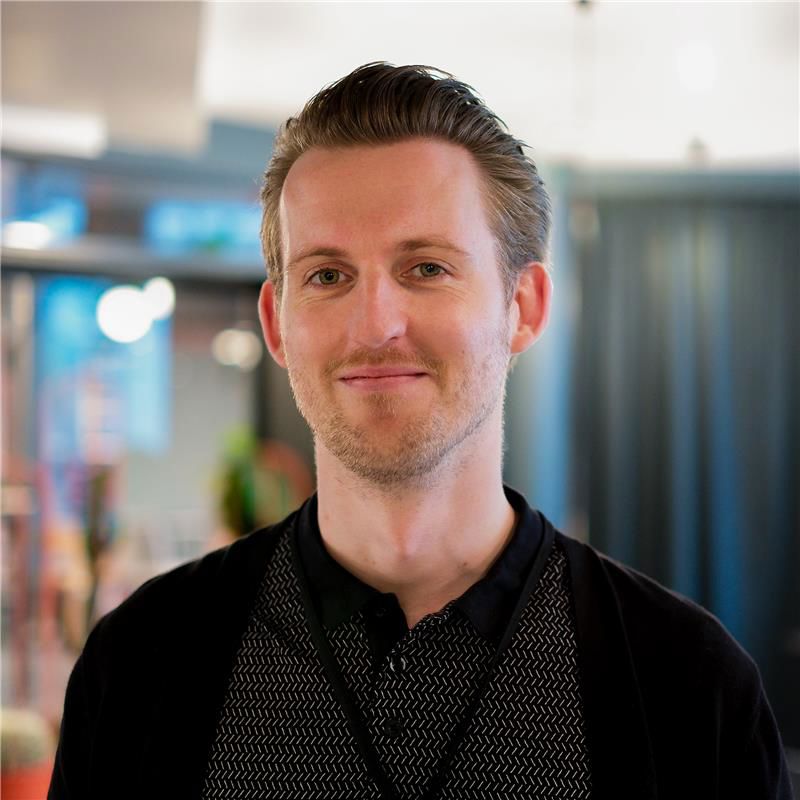 Mann smiler til kameraet