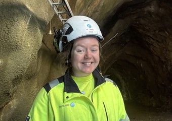 Dame i verneutstyr smiler til kameraet