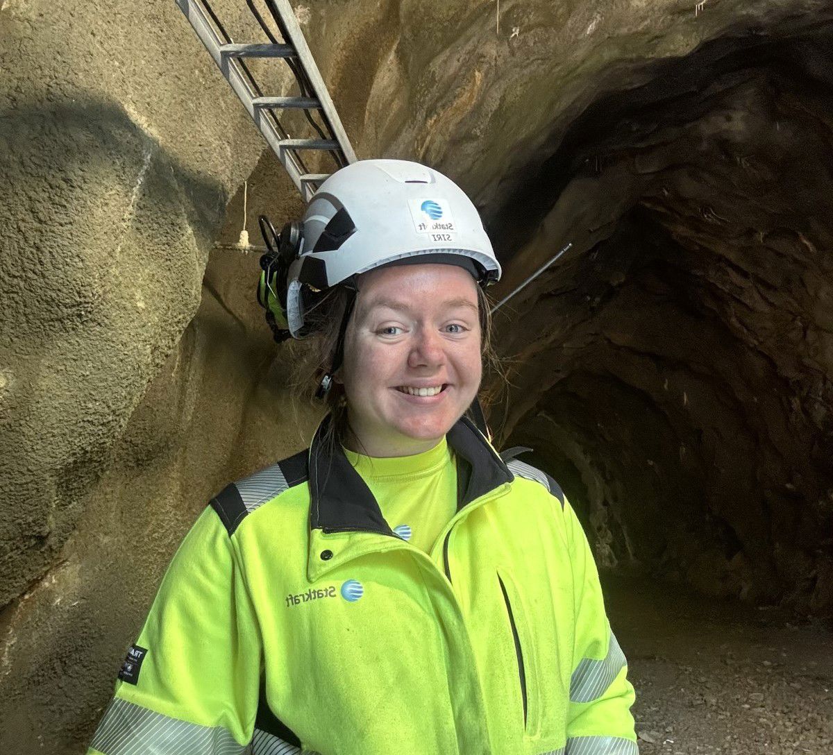 Dame i verneutstyr smiler til kameraet