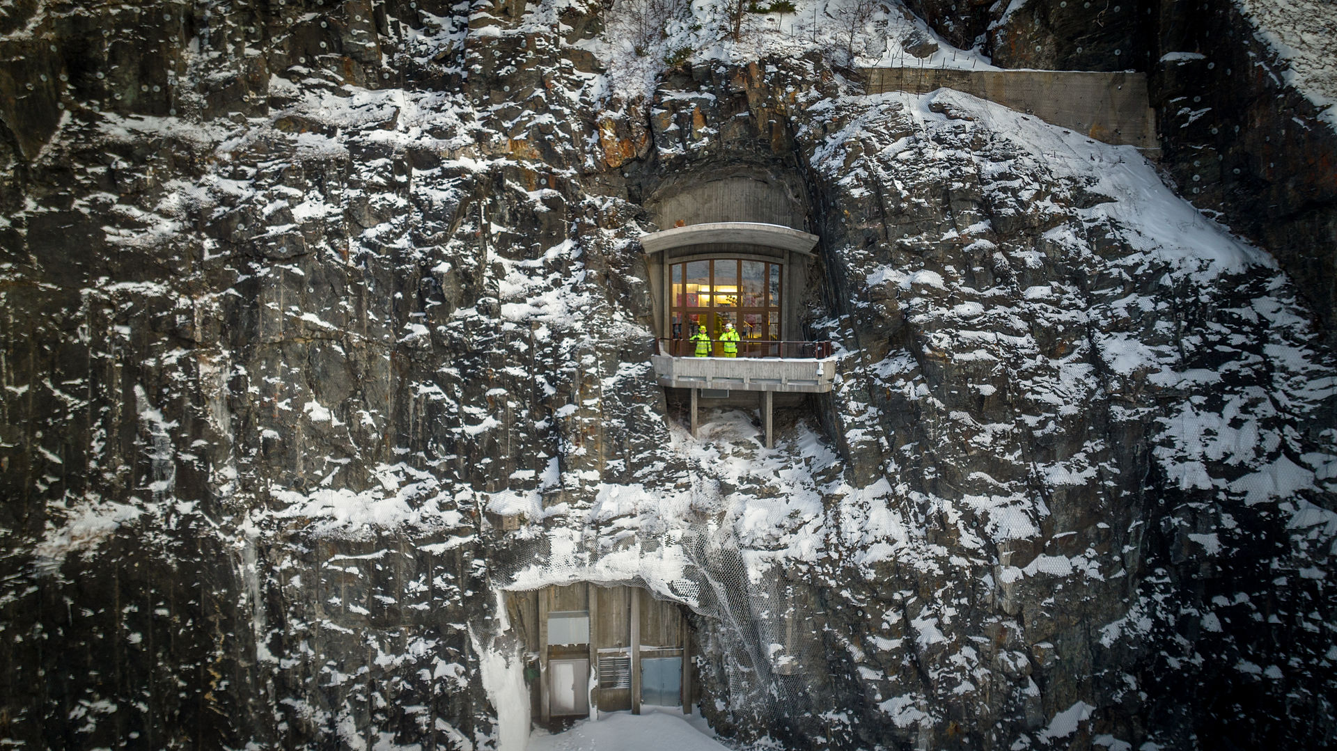 To ansatte står ved inngangen til vannkraftverket i fjellet