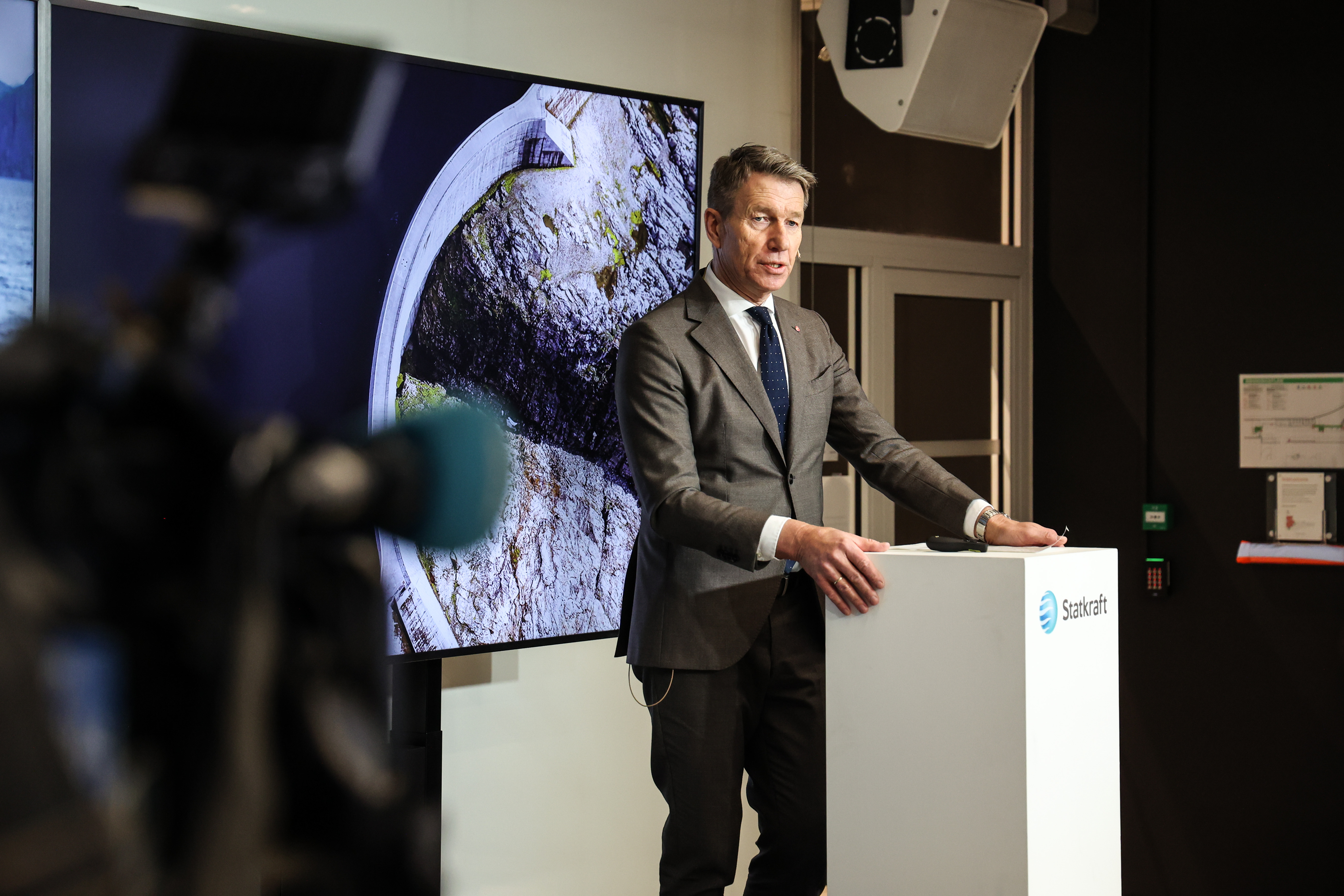 Mann står på et podium og snakker under en pressekonferanse