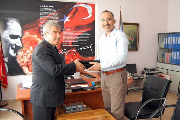 Bahadir Sezegen overrekker en Statkraft-PC til Mahmut Karakaş, overl&aelig;rer ved Gemici barneskole i Osmancik. 