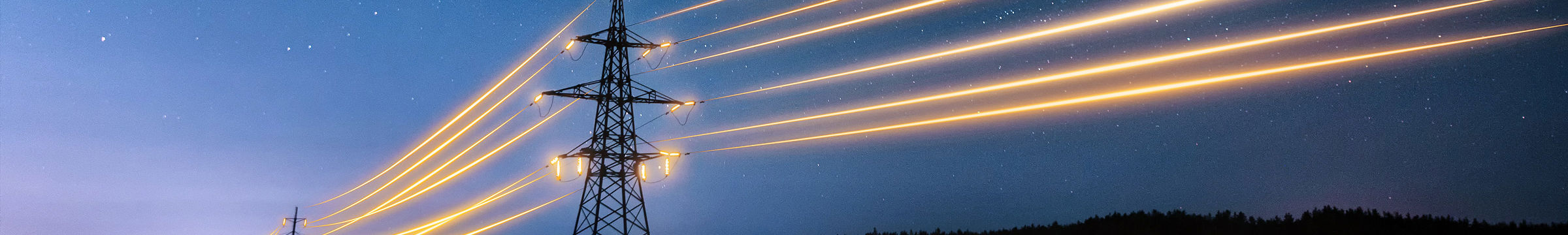 Lysende kraftlinjer mot nattehimmel