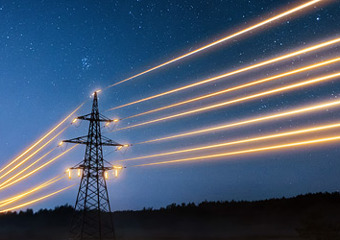 Lysende kraftlinjer mot nattehimmel