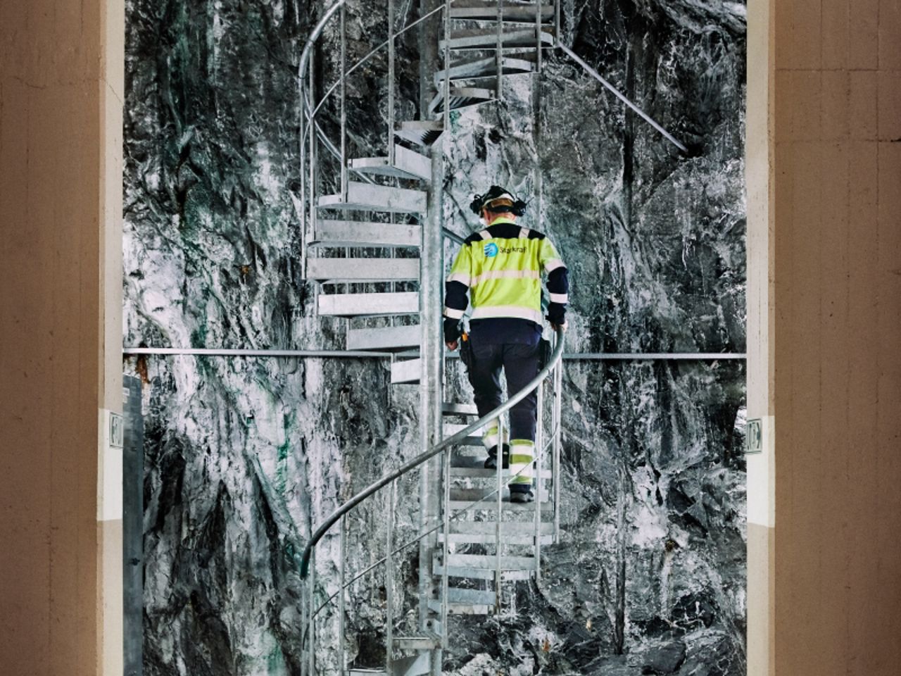 Mann går opp vindeltrapp inne i kraftverk