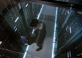 Mann med PC i rom med dataservere