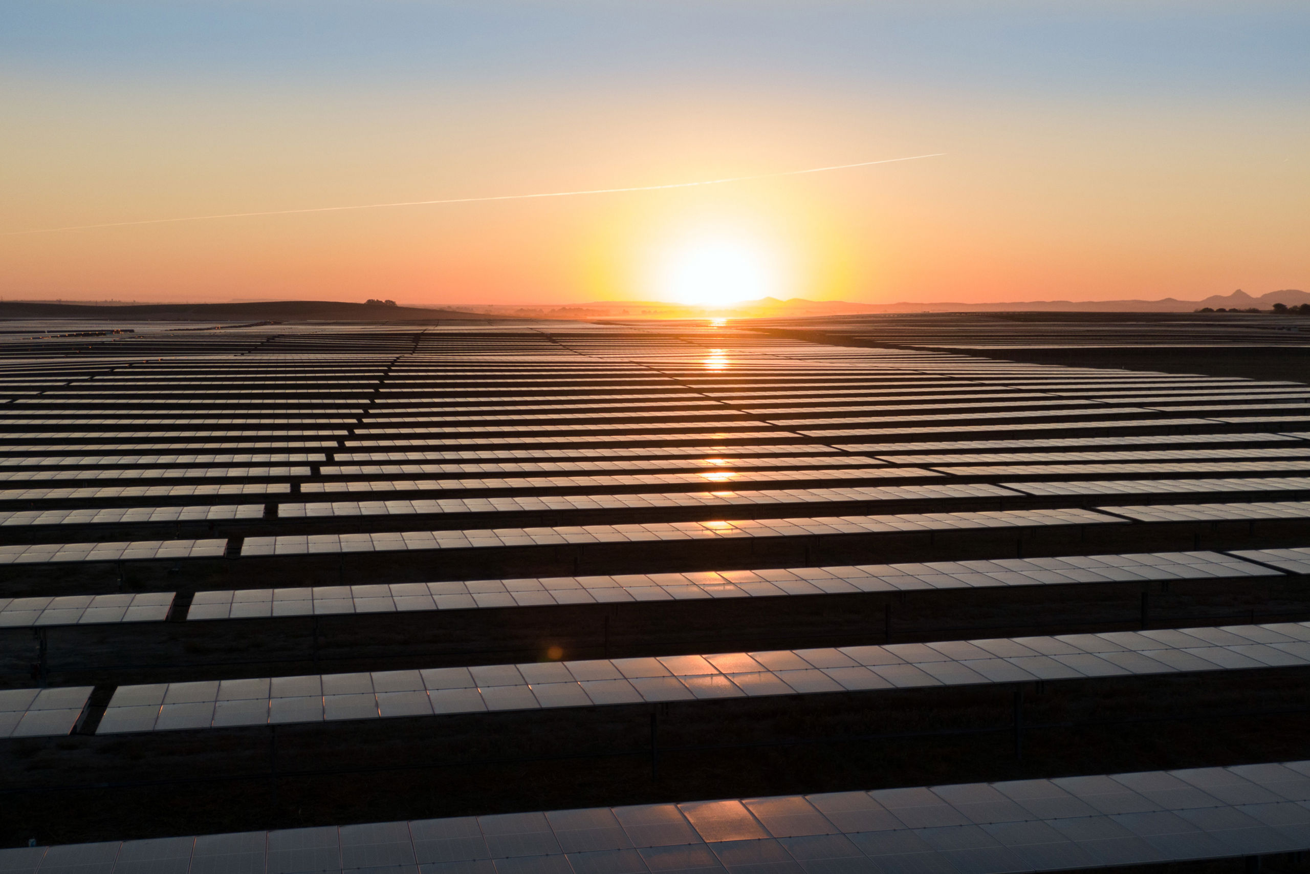 Solnedgang over solcellepaneler
