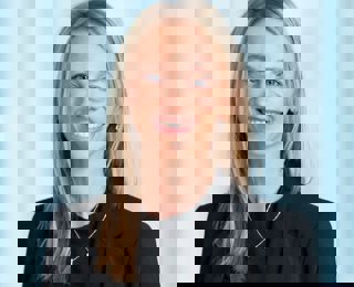 Woman in black suit smiling into the camera