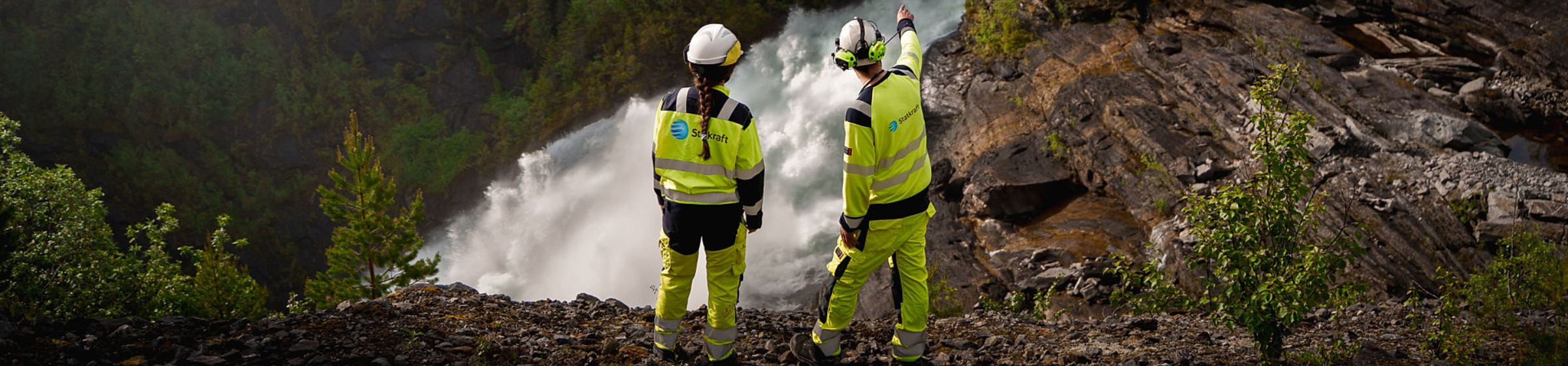 To ansatte står ved siden av en generator