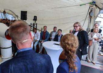 Dame snakker i paneldebatt på en båt