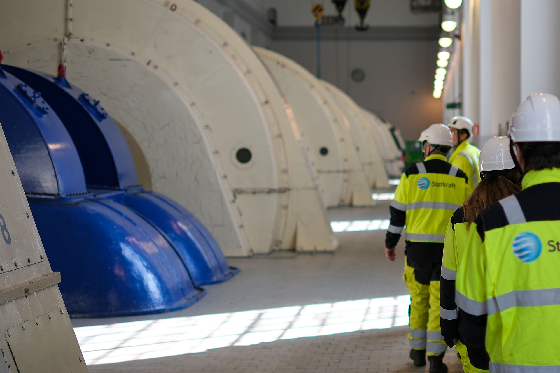 Flere ansatte går på omvisning på innsiden av en kraftstasjon