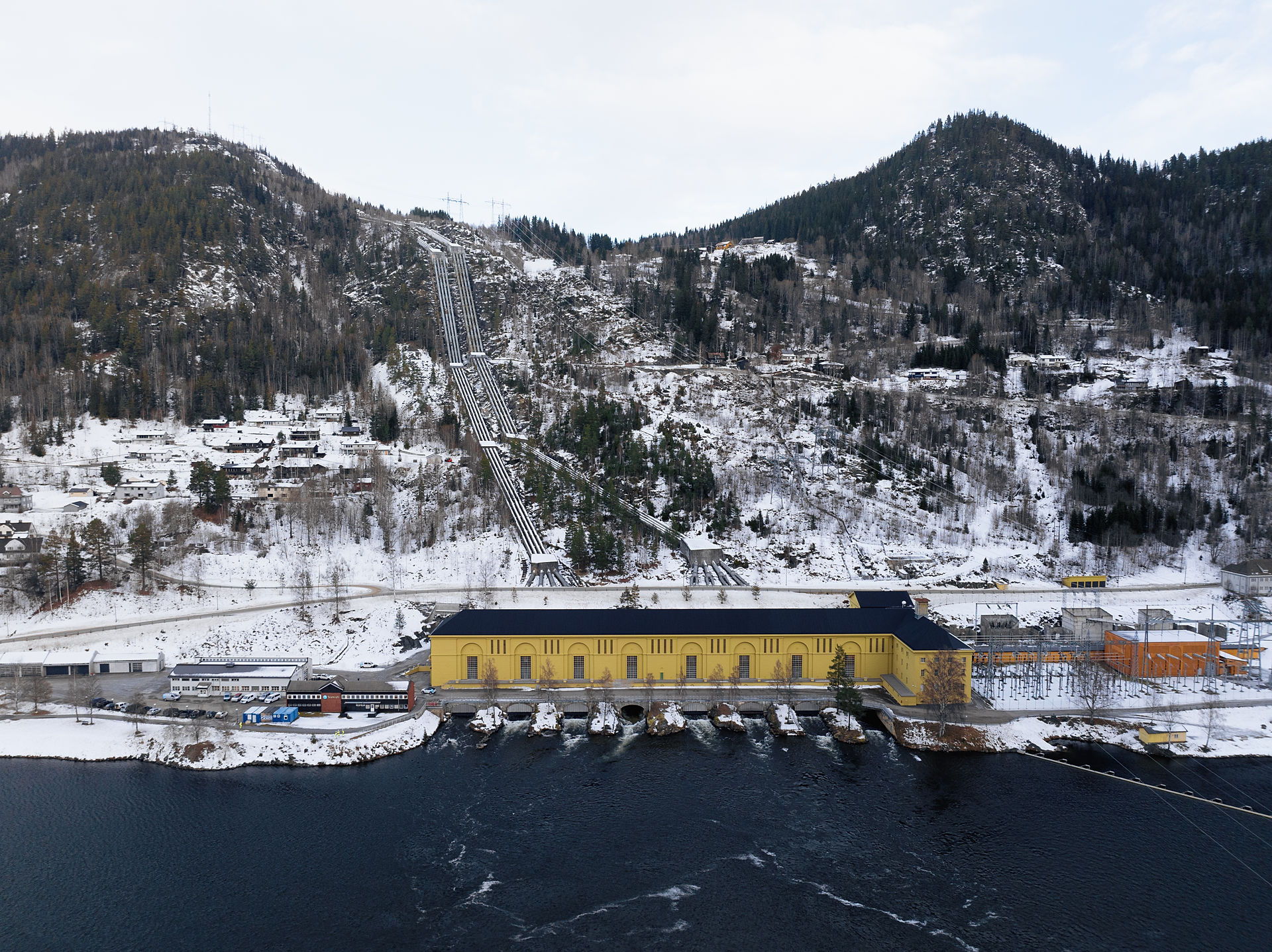 Gult kraftverksbygg i snølandskap