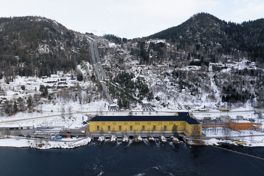 Gult kraftverksbygg i snølandskap