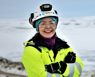 Dame i verneutstyr smiler