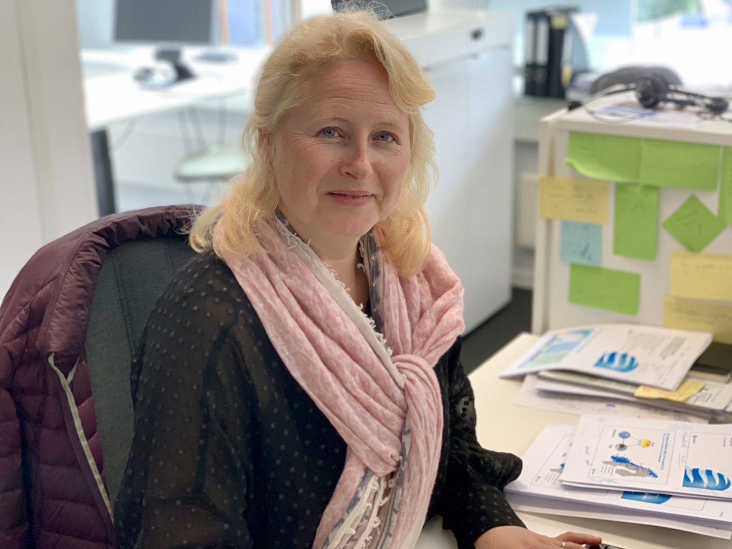 Marianne Holmen sitter ved en kontorpult