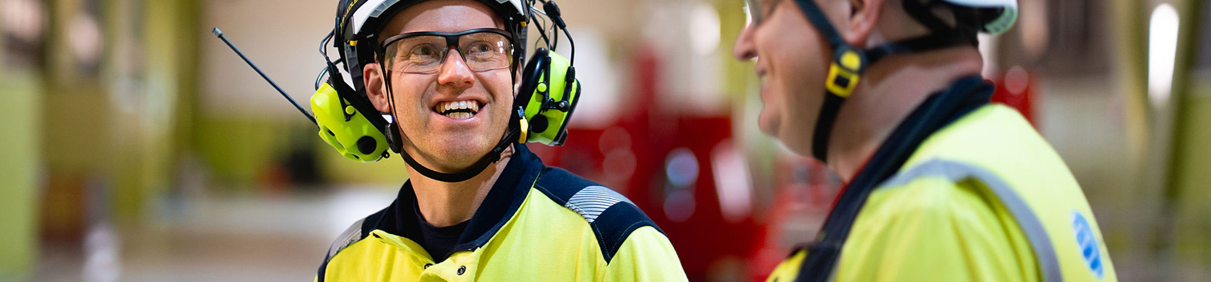 Lærling i verneutstyr snakker med kollega