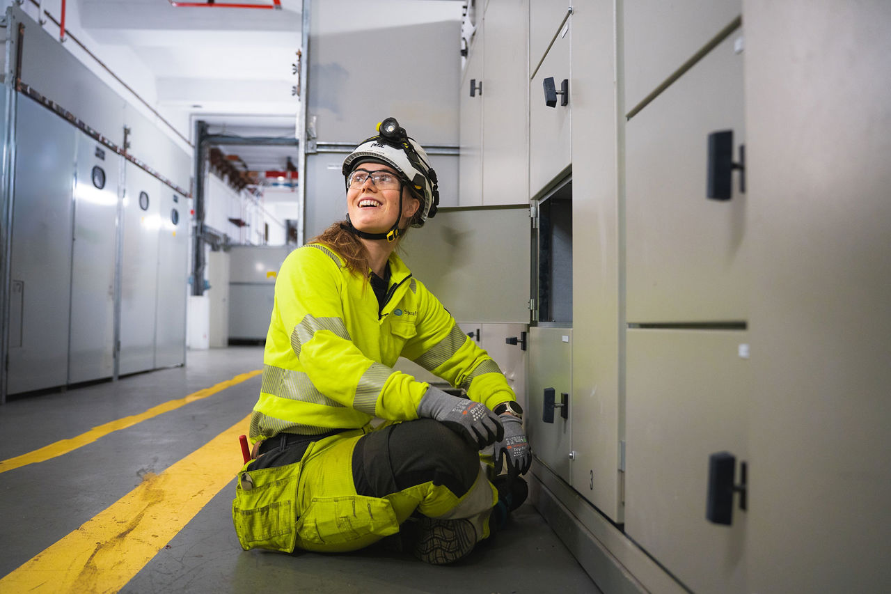 Dame i verneutstyr ser opp i taket