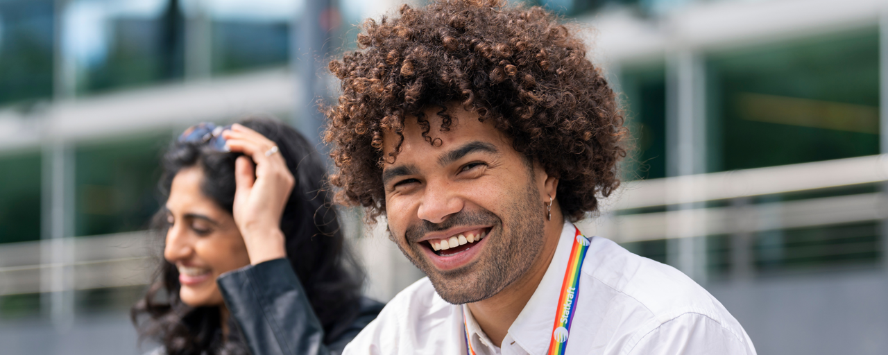 Mann i hvit skjorte smiler