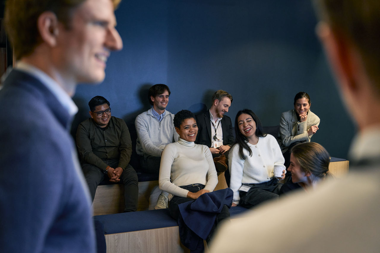 En gruppe mennesker følger med på en presentasjon