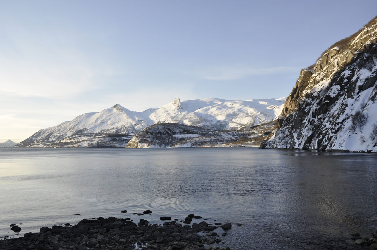 Snødekt fjellandskap ved siden av et vann