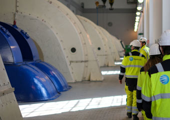 Ansatte i verneutstyr går inne i et vannkraftverk 