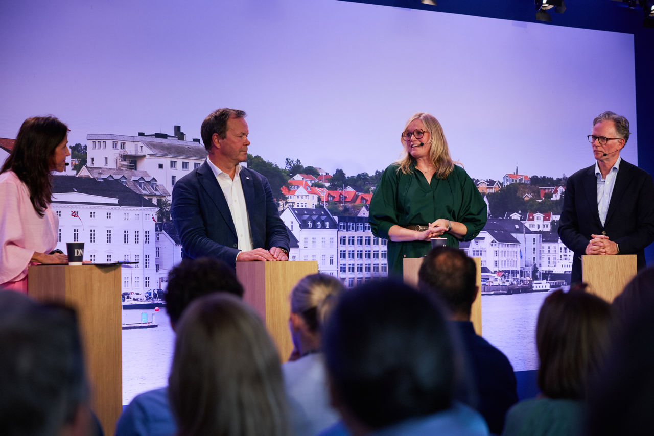Mennsker i debatt på en scene
