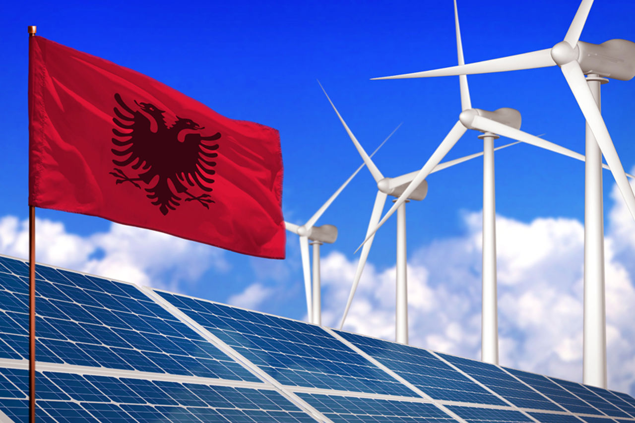 Albansk flagg foran solceller og vindturbiner