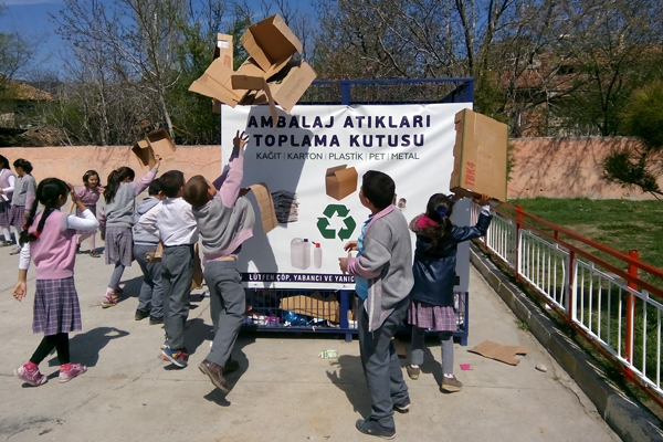 Barn kaster papp og papir i avfallsdunk