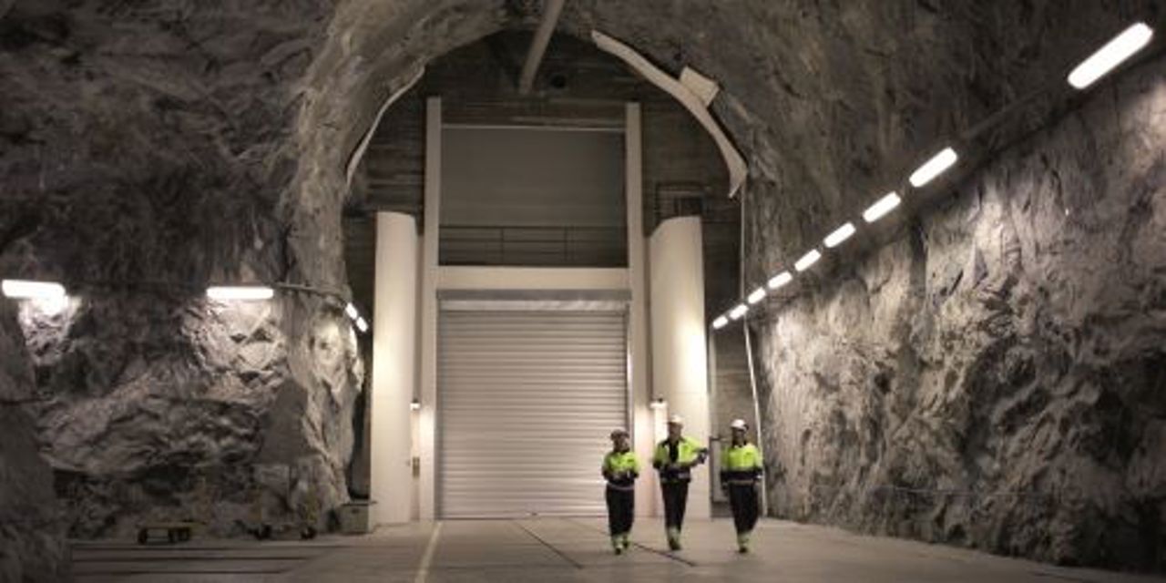 Tre arbeidere gående i tunnel