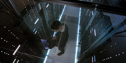 Mann med PC i rom med dataservere